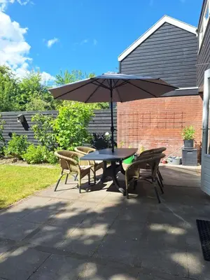 a table and chairs with an umbrella on a patio at Rekerlanden 32 in Schoorldam