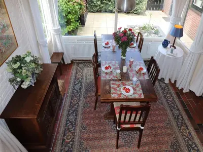 a dining room with a table with flowers on it at Holiday Home in Noordwijkerhout by Forest & Lake in Noordwijkerhout