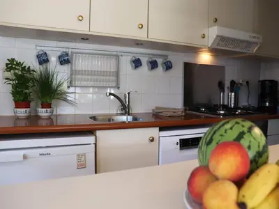 a kitchen with a bowl of fruit on a counter at Holiday Home in Noordwijkerhout by Forest & Lake in Noordwijkerhout