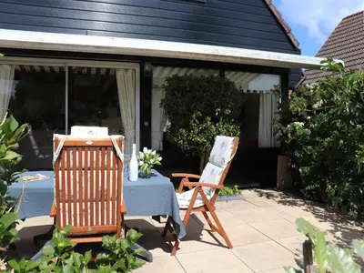 a table and two chairs on a patio at Holiday Home in Noordwijkerhout by Forest & Lake in Noordwijkerhout