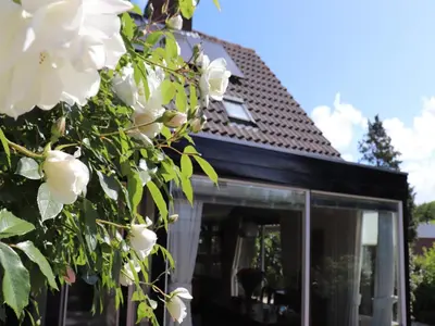 a house with white flowers in front of it at Holiday Home in Noordwijkerhout by Forest & Lake in Noordwijkerhout