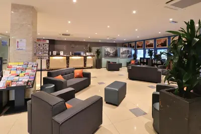 a waiting room with couches and chairs in a store at XO Hotels Blue Square in Amsterdam