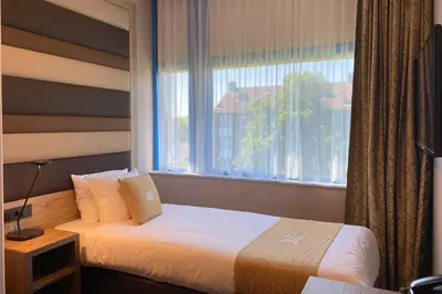 a hotel room with a bed and a window at XO Hotels Blue Square in Amsterdam