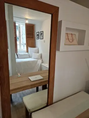 a mirror reflecting a room with a bed and a couch at New Apartment in the Heart of Amsterdam in Amsterdam