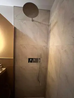 a bathroom with a shower with a glass door at Luxury Spa with Sauna, Bath and Cinema Private in Bodegraven
