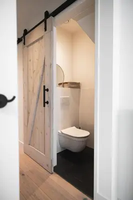 a bathroom with a toilet and a wooden door at Pakhuys 15 in Alkmaar