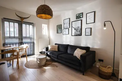 a living room with a black couch and a table at Pakhuys 15 in Alkmaar