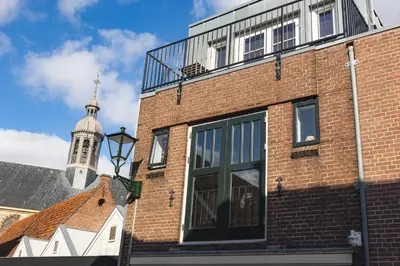 a brick building with a clock tower in the background at Pakhuys 15 in Alkmaar