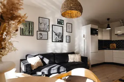 a living room with a black couch and pictures on the wall at Pakhuys 15 in Alkmaar