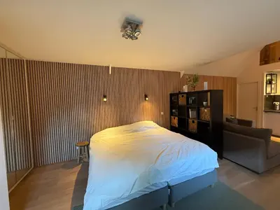 a bedroom with a large bed and a couch at Stolp & Stay in Broek in Waterland