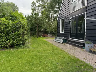 a yard with a bench next to a house at Stolp & Stay in Broek in Waterland