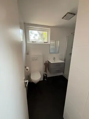 a bathroom with a toilet and a sink and a window at Stolp & Stay in Broek in Waterland