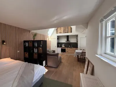 a bedroom with a bed and a living room at Stolp & Stay in Broek in Waterland