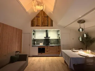 a living room with a table and a kitchen at Stolp & Stay in Broek in Waterland