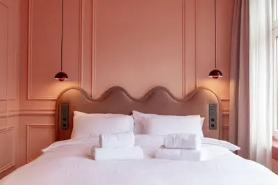 a bedroom with a white bed with three pillows at Suite Palette in Amsterdam
