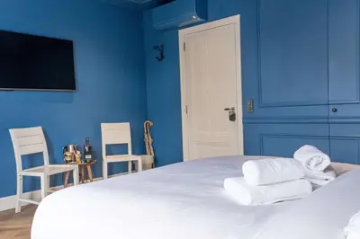 a blue bedroom with a bed with towels on it at Suite Palette in Amsterdam
