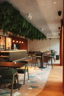 a restaurant with tables and chairs and a bar at Hotel V Oosterpark in Amsterdam