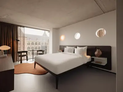a bedroom with a white bed and a large window at Hotel V Oosterpark in Amsterdam
