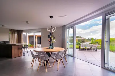 a kitchen and dining room with a table and chairs at Watervilla van Francke by Droomvilla in Ons Belang