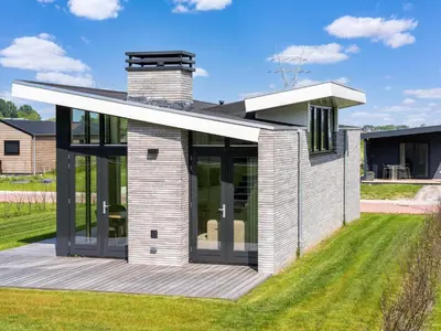 a house with glass doors on a lawn at Holiday Home in Oud Ade near Kaag Lakes in Oud-Ade