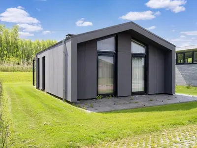 a black modular house on a grass field at Holiday Home near Kaag Lakes and Leiden Canals in Oud-Ade