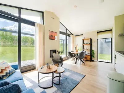 a living room with a blue couch and a table at Holiday Home near Kaag Lakes and Leiden Canals in Oud-Ade