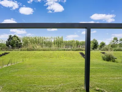 a view of a field through a window at Holiday Home near Kaag Lakes and Leiden Canals in Oud-Ade