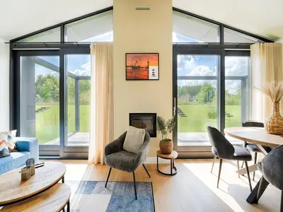 a living room with large windows and a table and chairs at Holiday Home near Kaag Lakes and Leiden Canals in Oud-Ade