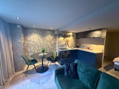 a kitchen and a living room with a couch and a table at Katwijks geluk in Katwijk aan Zee