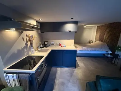 a kitchen with a sink and a bed in a room at Katwijks geluk in Katwijk aan Zee
