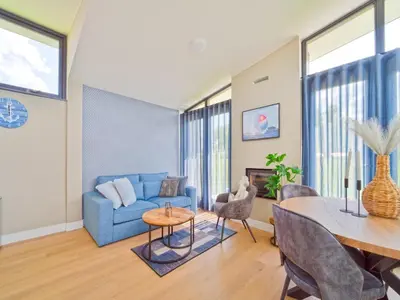 a living room with a blue couch and a table at Holiday Home in Oud Ade near Kaag Lakes in Oud-Ade