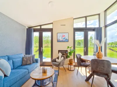a living room with a blue couch and a table at Holiday Home in Oud Ade near Kaag Lakes in Oud-Ade