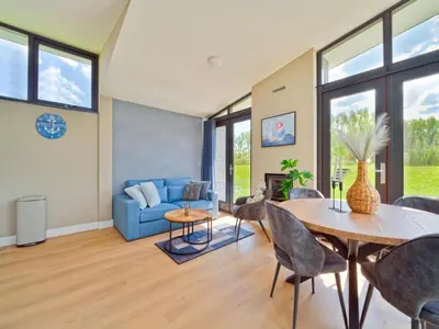 a living room with a table and a blue couch at Holiday Home in Oud Ade near Kaag Lakes in Oud-Ade