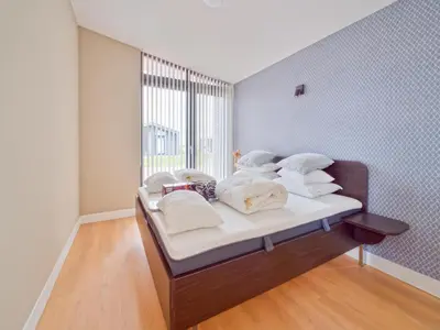 a bed with white towels and a window in a room at Holiday Home in Oud Ade near Kaag Lakes in Oud-Ade