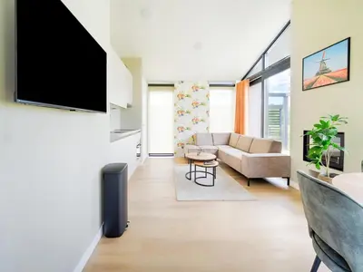 a living room with a tv and a couch at Holiday Home Oud Ade near Kaag Lakes in Oud-Ade