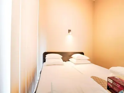 a bedroom with a bed with white sheets and pillows at Holiday Home Oud Ade near Kaag Lakes in Oud-Ade