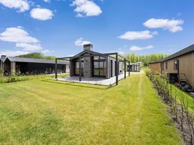 a house with a large yard next to a building at Holiday Home Oud Ade near Kaag Lakes in Oud-Ade