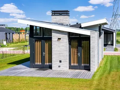 a house with glass doors on a deck at Holiday Home in Oud Ade near Kaag Lakes in Oud-Ade