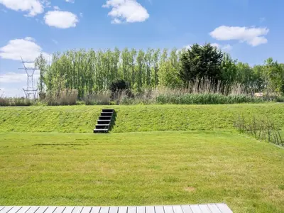 a grassy field with a staircase in the middle of it at Holiday Home in Oud Ade near Kaag Lakes in Oud-Ade