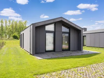 a black and white house on a grass field at Holiday Home in Oud Ade near Kaag Lakes in Oud-Ade