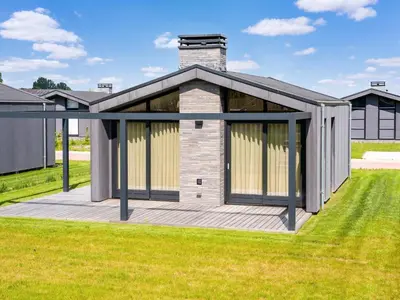 a house with a deck in the grass at Holiday Home in Oud Ade near Kaag Lakes in Oud-Ade