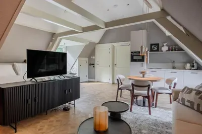 a living room with a television and a table and chairs at Huize Randenbroek Amersfoort in Amersfoort
