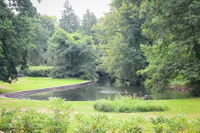 a pond in a park with trees and a river at Huize Randenbroek Amersfoort in Amersfoort