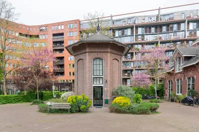 a brick building with a statue on top of it at Unique 3 floor apartment with AC at Westerpark in Amsterdam