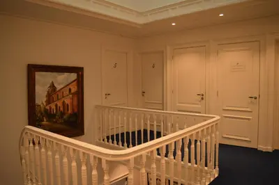 a white staircase in a room with a painting at Herberg Welgelegen in Katwijk