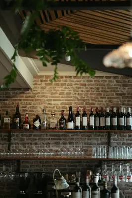 a row of bottles of wine on a brick wall at Herberg Welgelegen in Katwijk