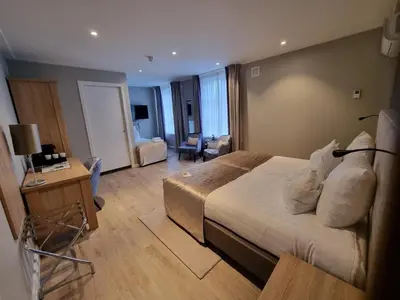 a hotel room with a bed and a living room at Herberg Welgelegen in Katwijk
