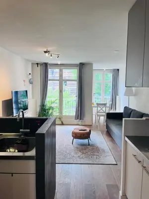 a kitchen and living room with a couch and a table at Cozy museum area home in Amsterdam