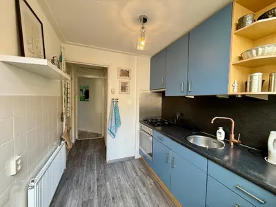 a kitchen with blue cabinets and a sink at Noordwijk-sur-mer in Noordwijk aan Zee