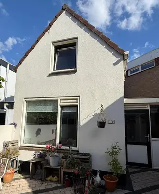 a white house with potted plants in front of it at Noordwijk-sur-mer in Noordwijk aan Zee